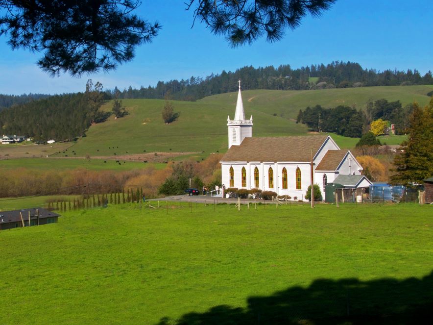 A white church surrounded by green pasture