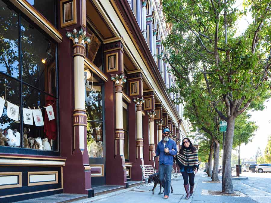 People walk past Victorian buildings