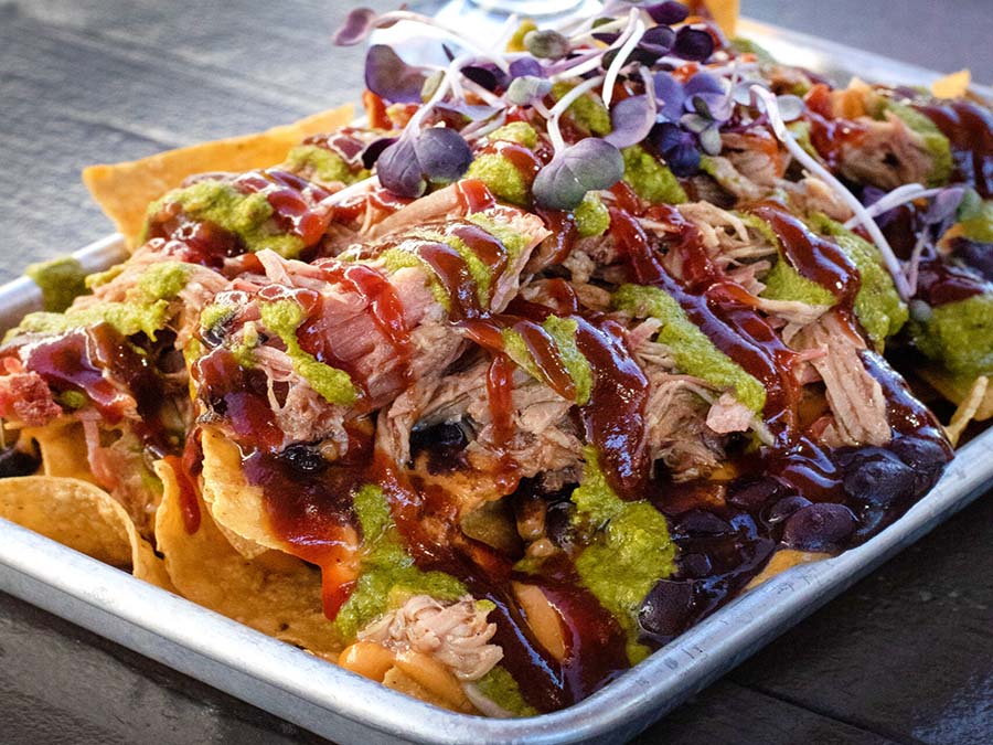 Barbecue nachos with pulled pork, nacho cheese, barbecue sauce, black beans and chimmichurri at Austin’s Barbecue at Old Possum Brewing. 