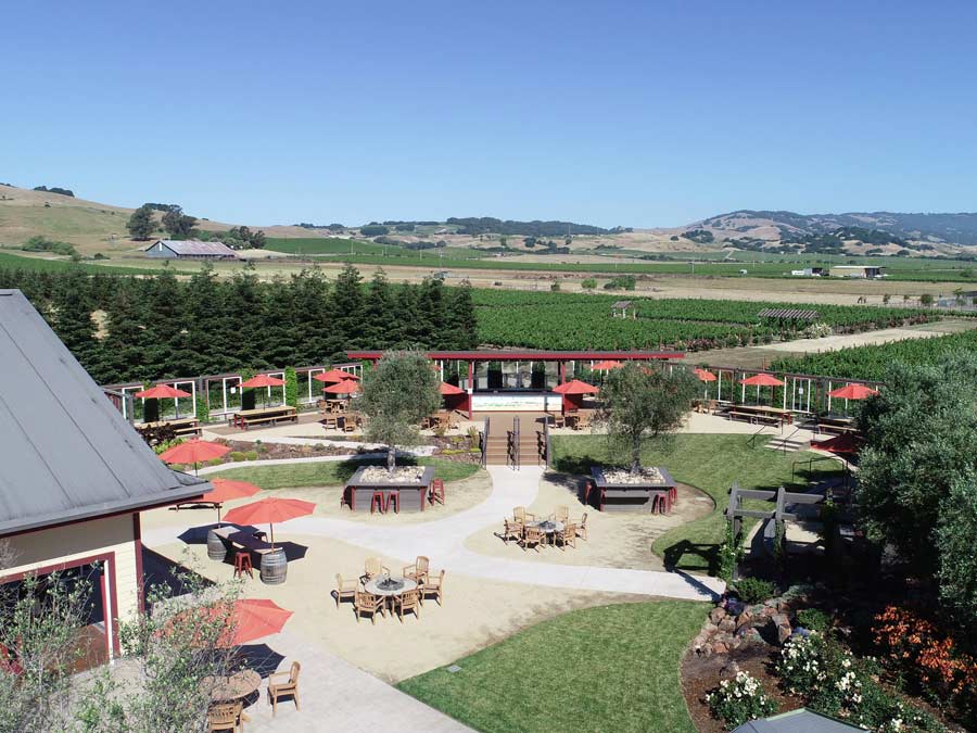 An aerial view of picnic tables in a plaza next to the vineyard