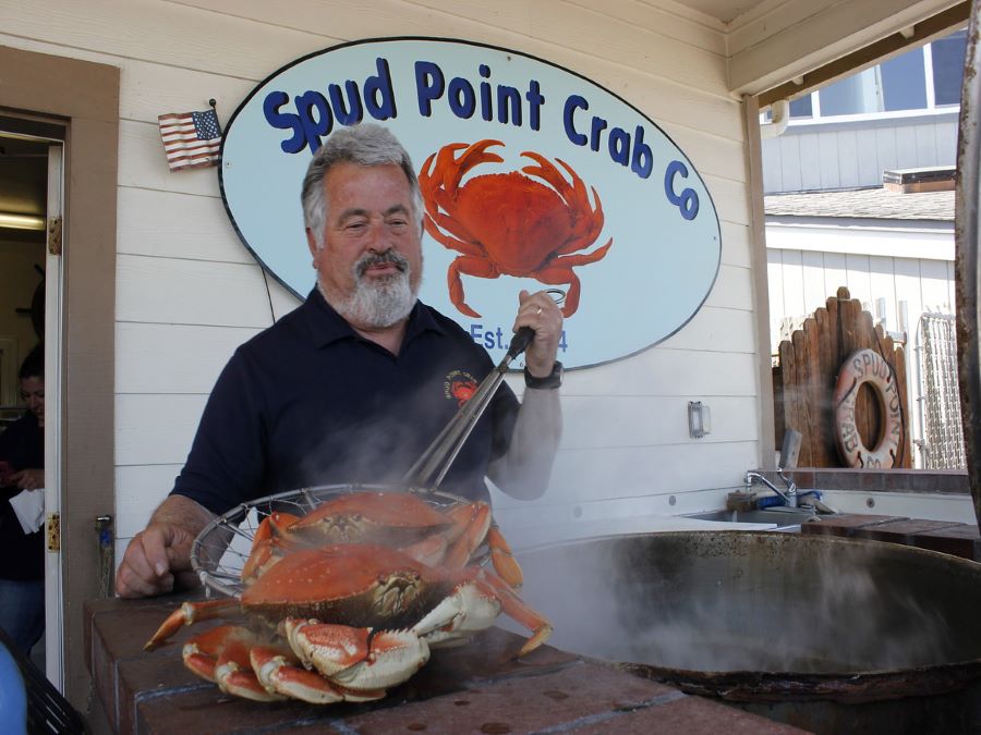 A man pulls crabs out of a steaming pot