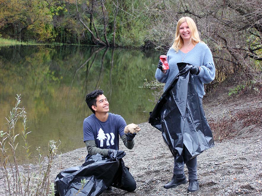 Image of two people picking up trash at Steelhead Beach Regional Park.