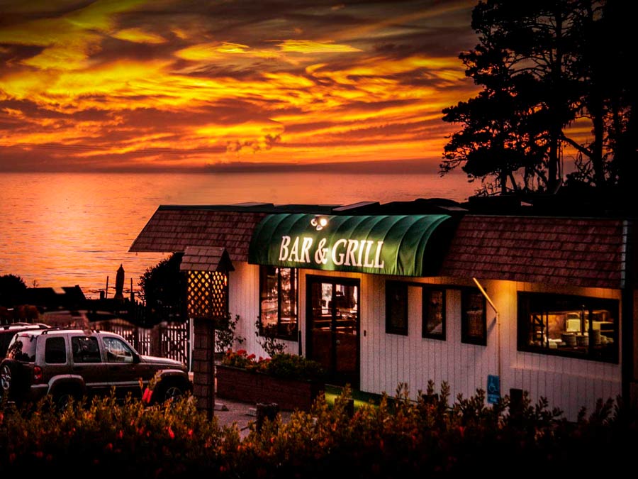 The sun sets along the Sonoma Coast behind the Ocean Cove Lodge Bar & Grill, Jenner