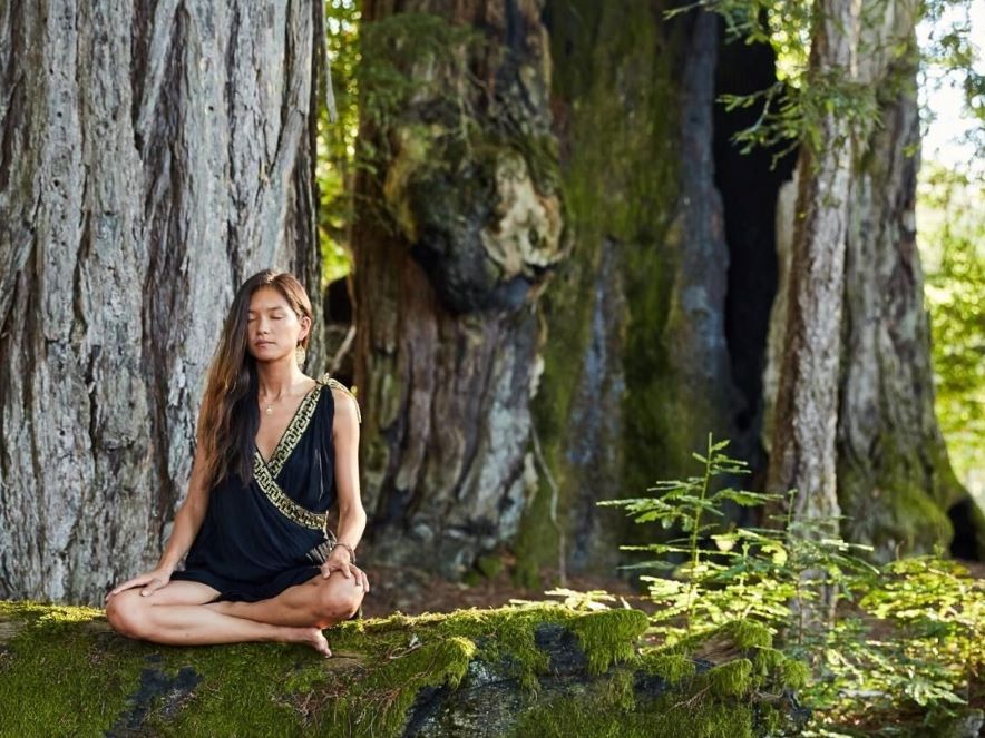 Picture of woman meditating next to a tree