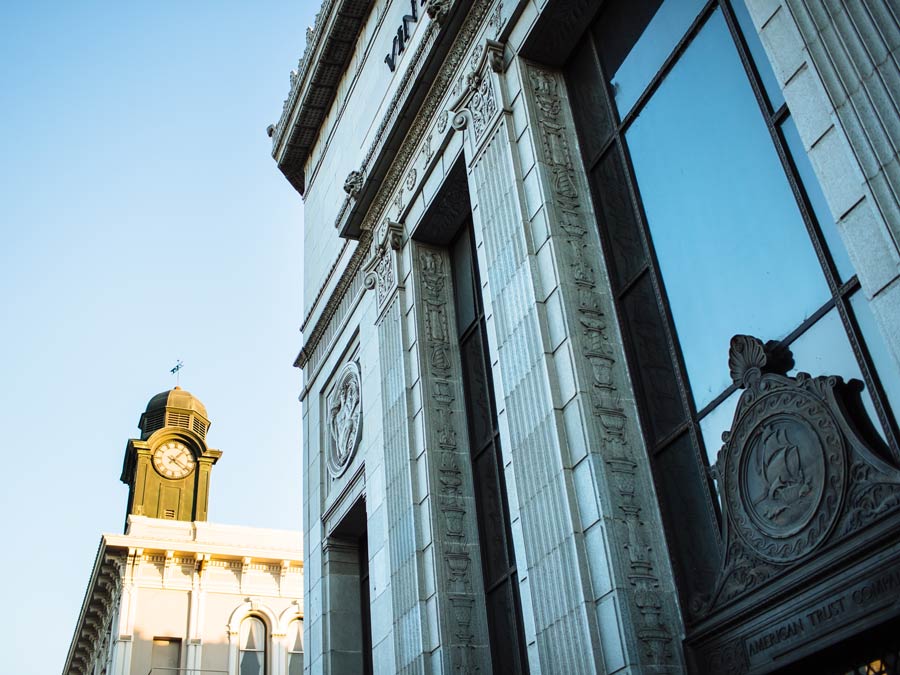 A clock tower next to a Victorian building 