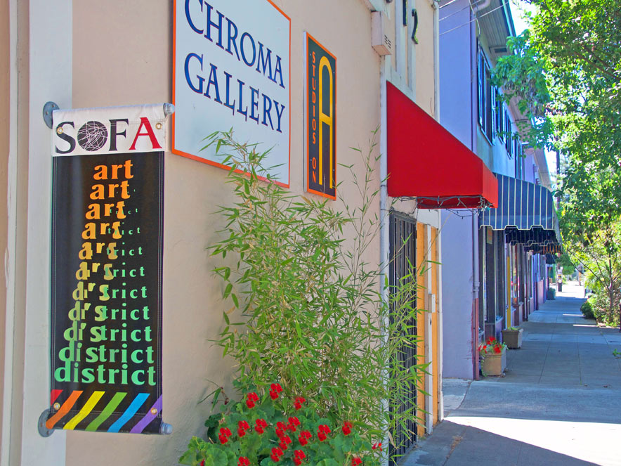 A colorful sign for SOFA hangs on the outside of a gallery wall