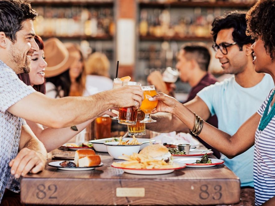 Picture of group of friends around table toasting glasses