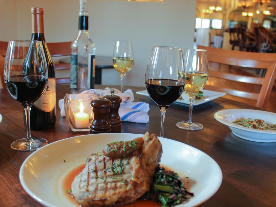 A chicken breast served on top of vegetables by candlelight