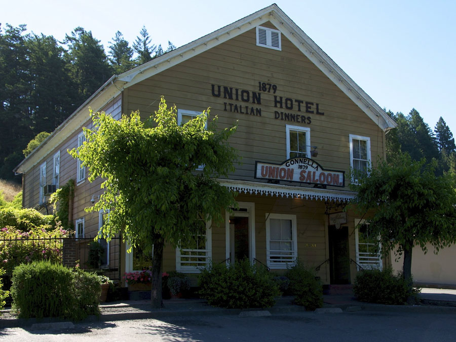 The outside of the restaurant is flanked by redwoods in Occidental