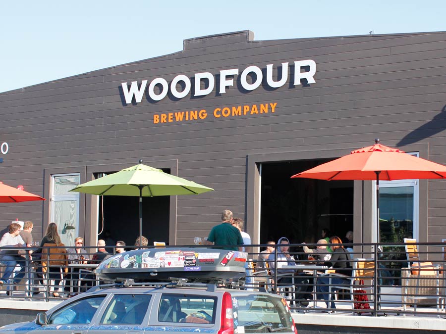 The patio in front of Woodfour Brewing has tables with colorful umbrellas in Sonoma County