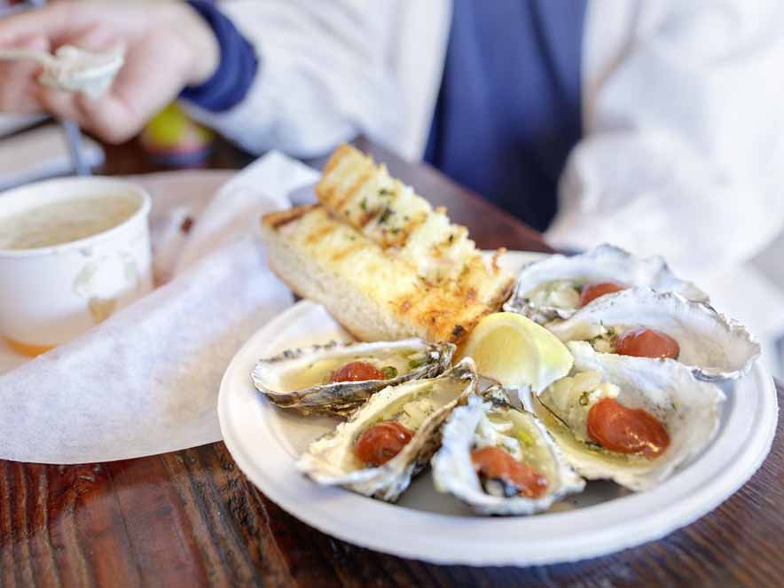 oysters, bread, and chowder on picnic table