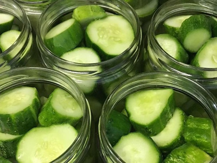 Cucumber slices in Mason jars, ready for pickling