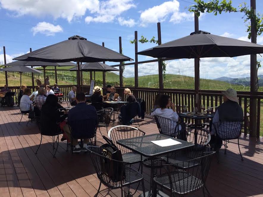 People sitting at various tables on the outdoor deck at Karah Estate Vineyard