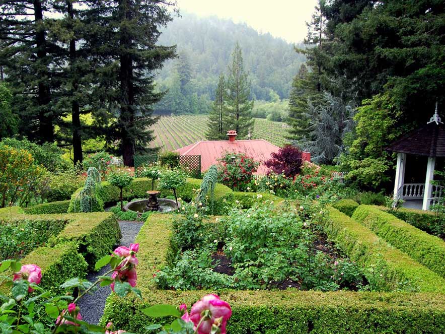 gardens among tall trees with building in far view