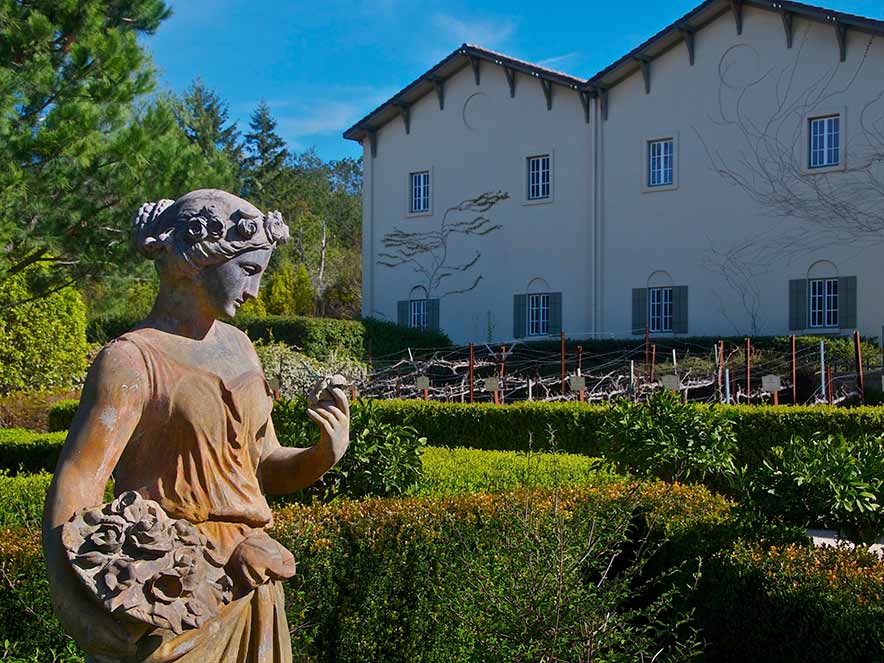 A sculpture of a person sits in the garden of the chateau