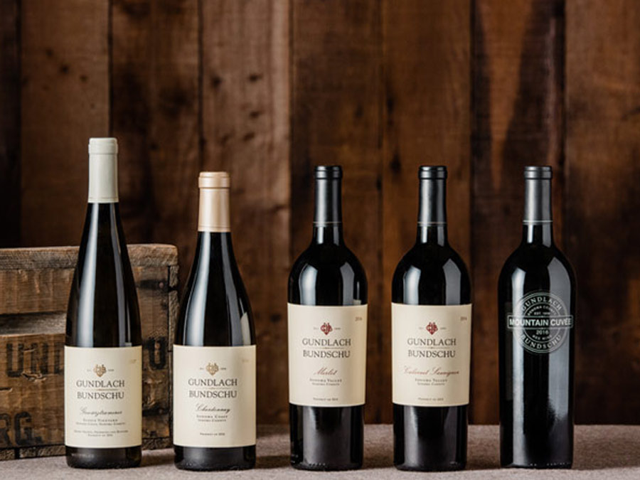 Bottles of wine lined up on a wooden table