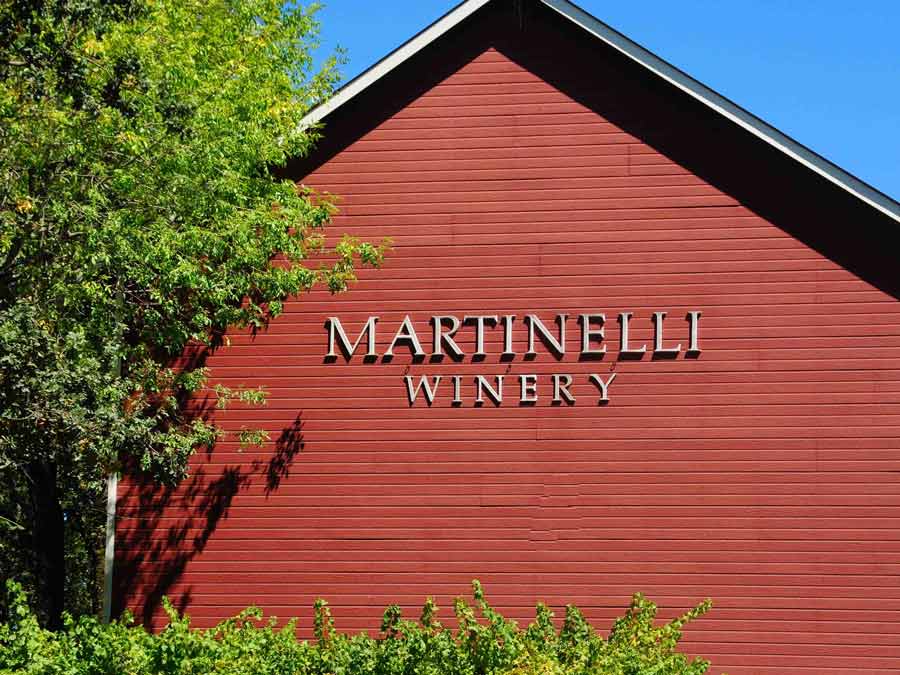 The red barn of Martinelli Winery & Vineyards shines in the sun in Sonoma County