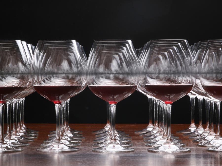 Glasses of red wine lined up on a table