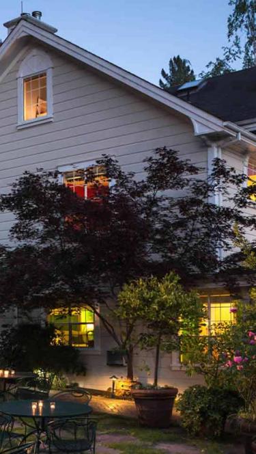 The inn at sunset is surrounded by trees