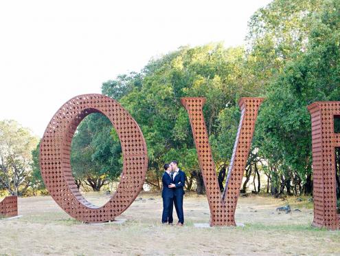 large love sculpture with two men kissing in front