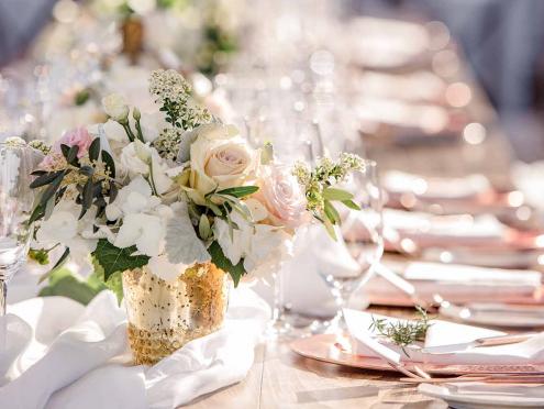 table setting with white flowers and pink napkins