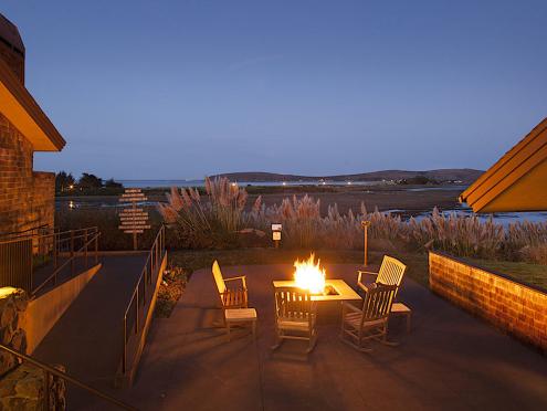 Rocking chairs around a firepit at dusk beside Bodega Bay at Drake's Sonoma Coast Kitchen 