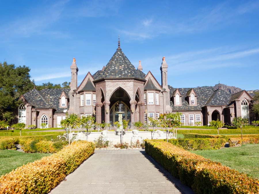 A formal walkway leads up to the castle like winery